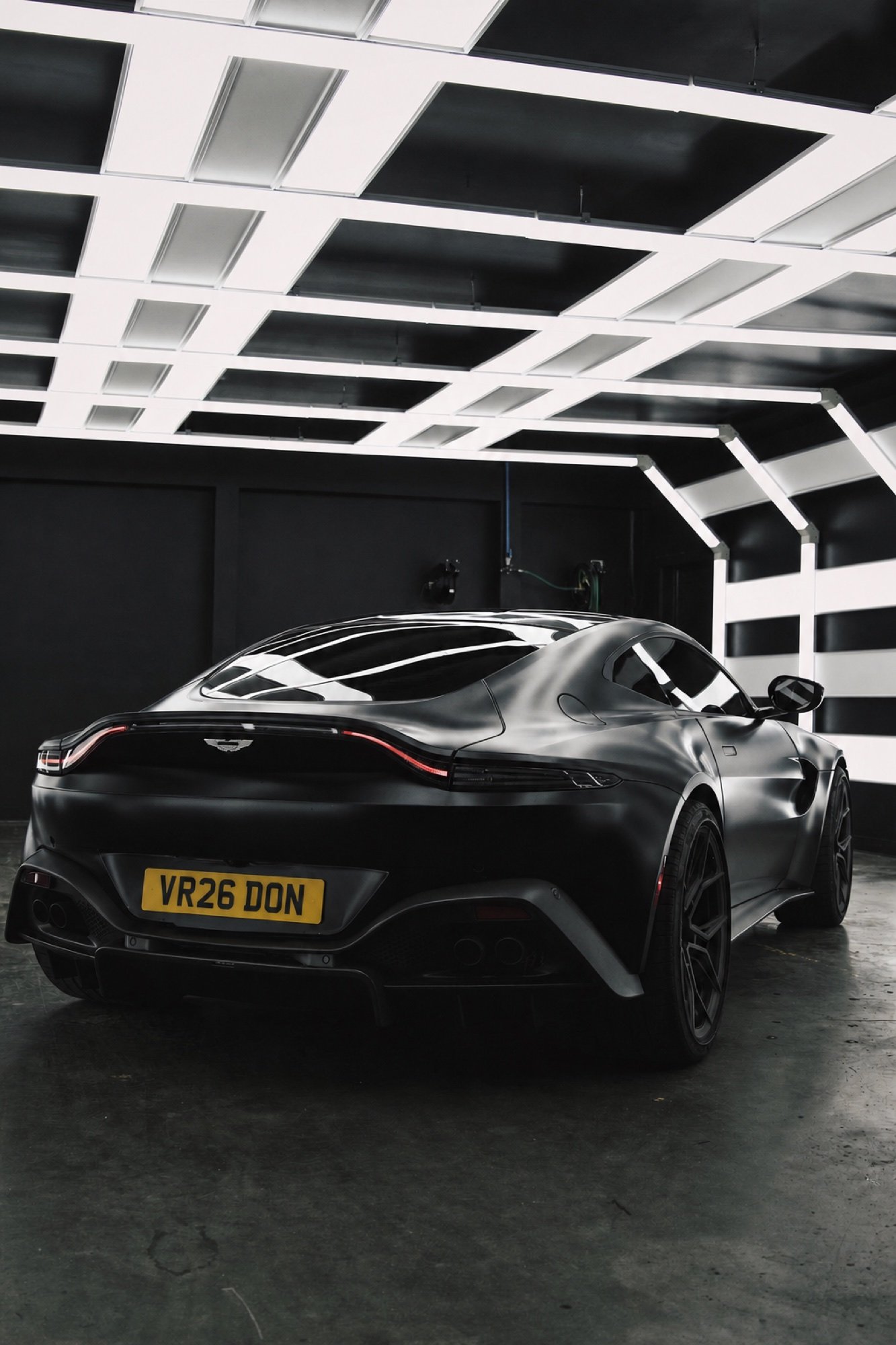 A black grand tourer presented in a private automotive setting