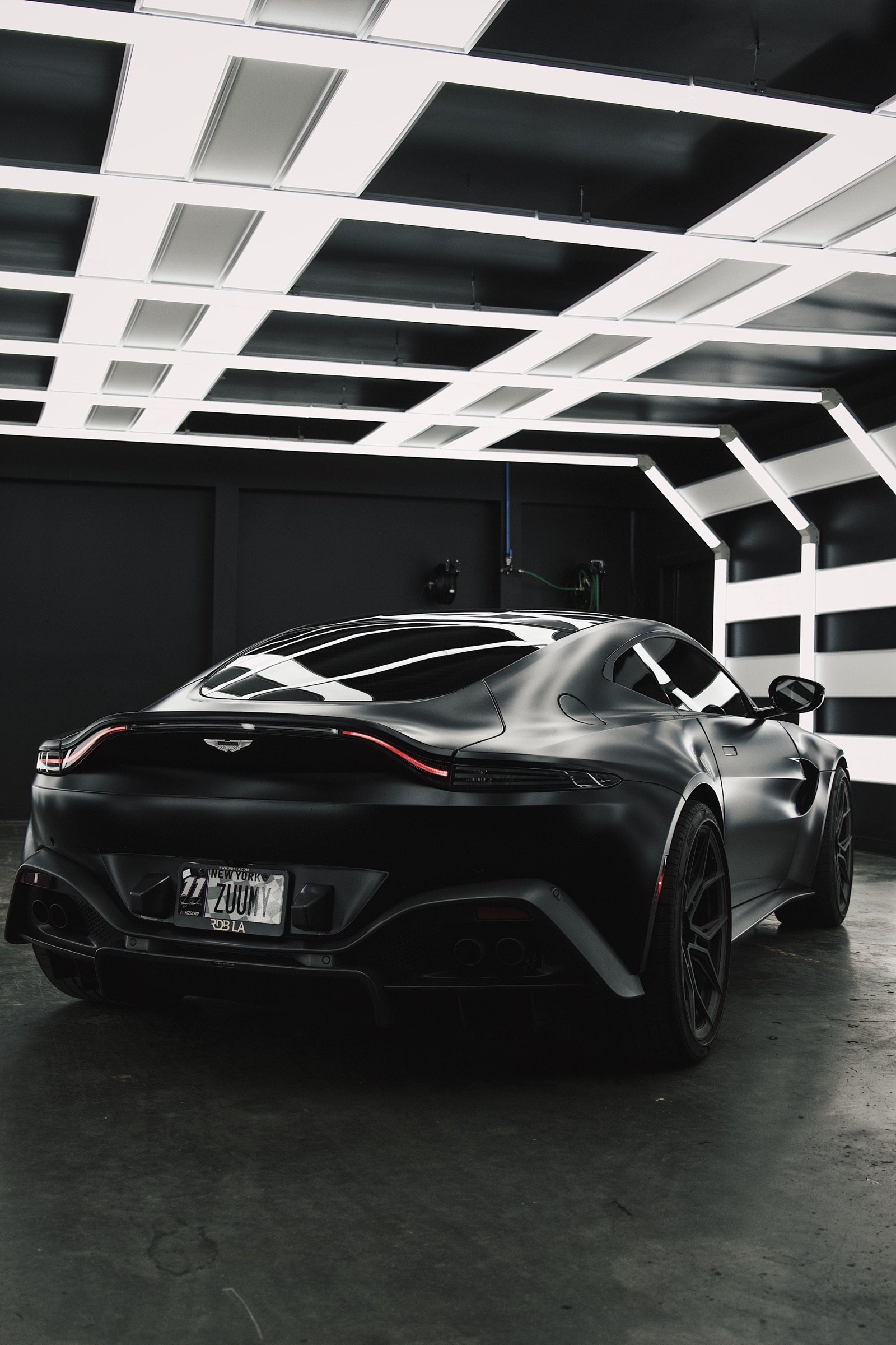 A dark specialist sports car under considered presentation lighting